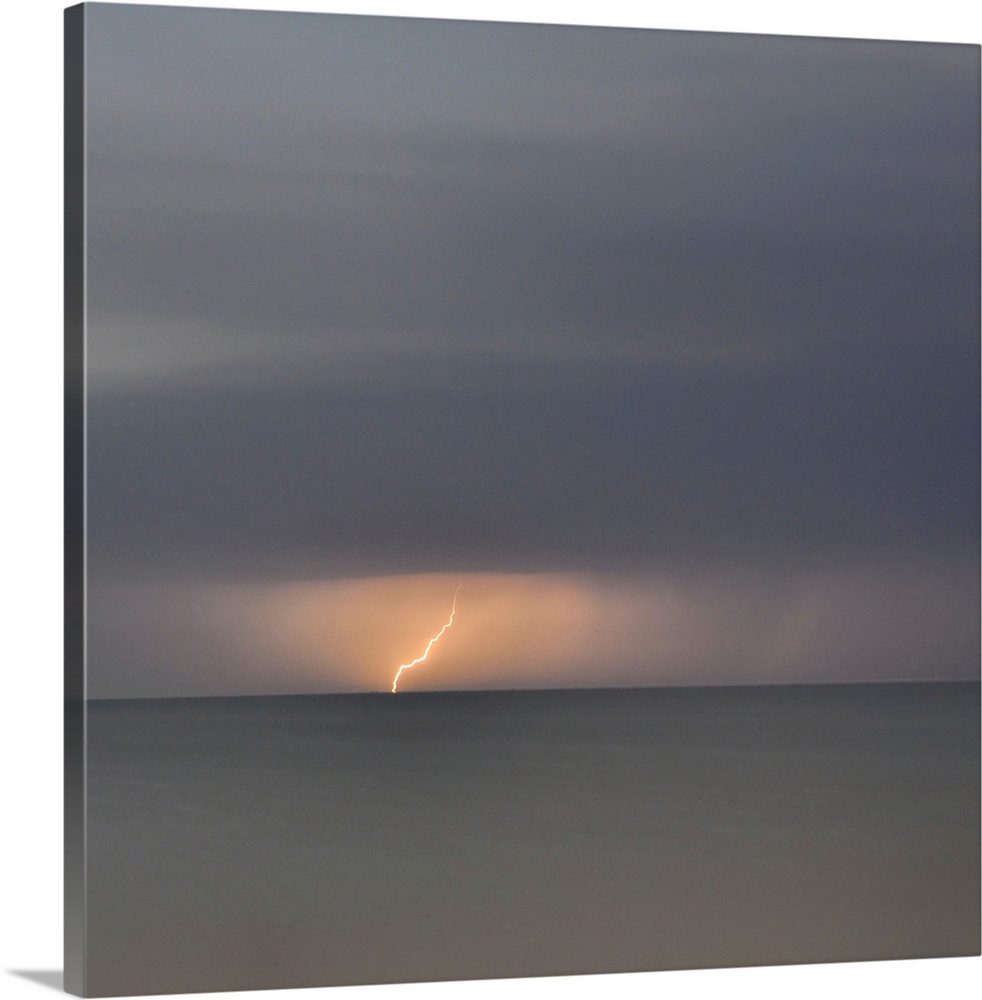Square picture of a storm flash above a long time exposure sea.