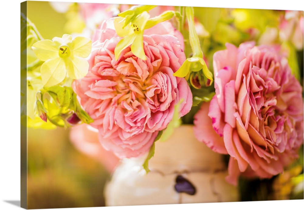 Close-up photograph of pink English roses in an arrangement with a shallow depth of field.