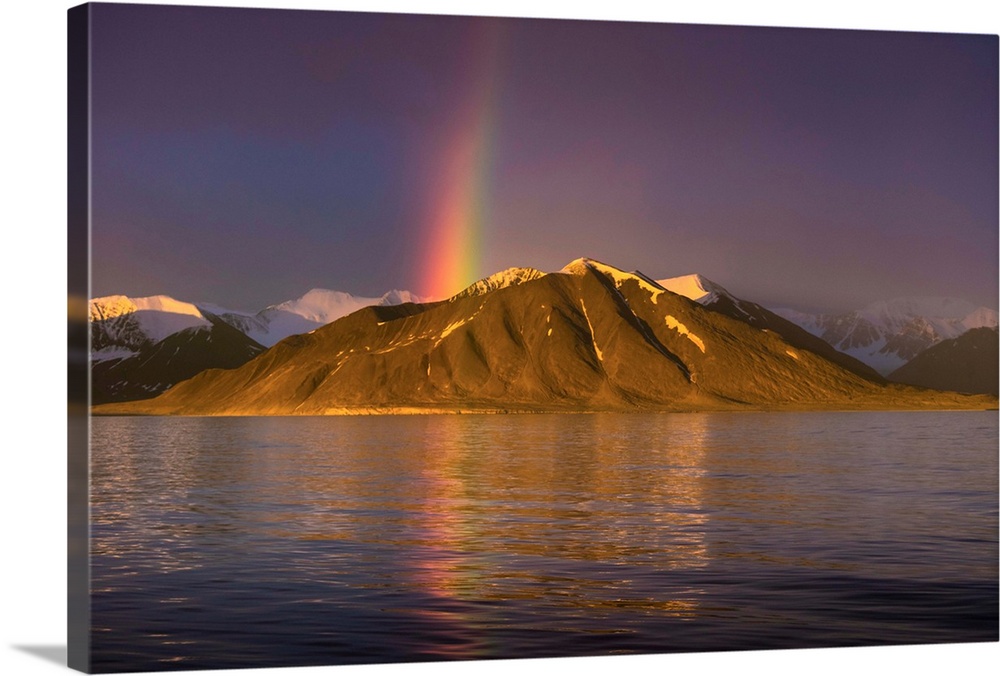 Fine art photograph of a rainbow over a mountain on the Norwegian coast.