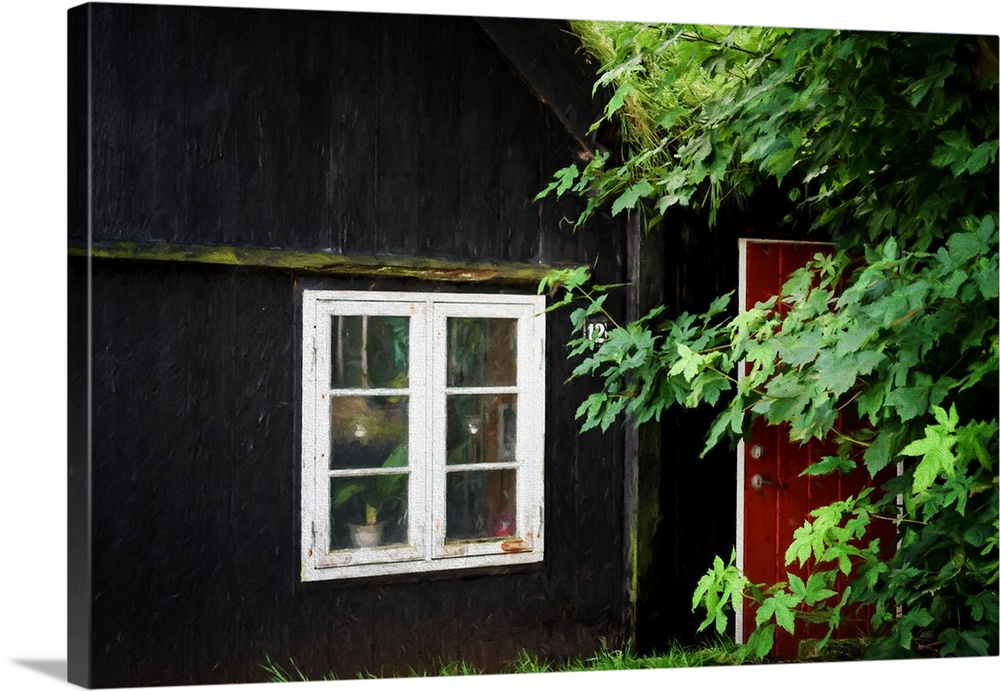 A black painted house with a bright red door and a white window.