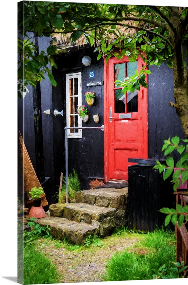 A black painted house with a bright red door and stone steps.