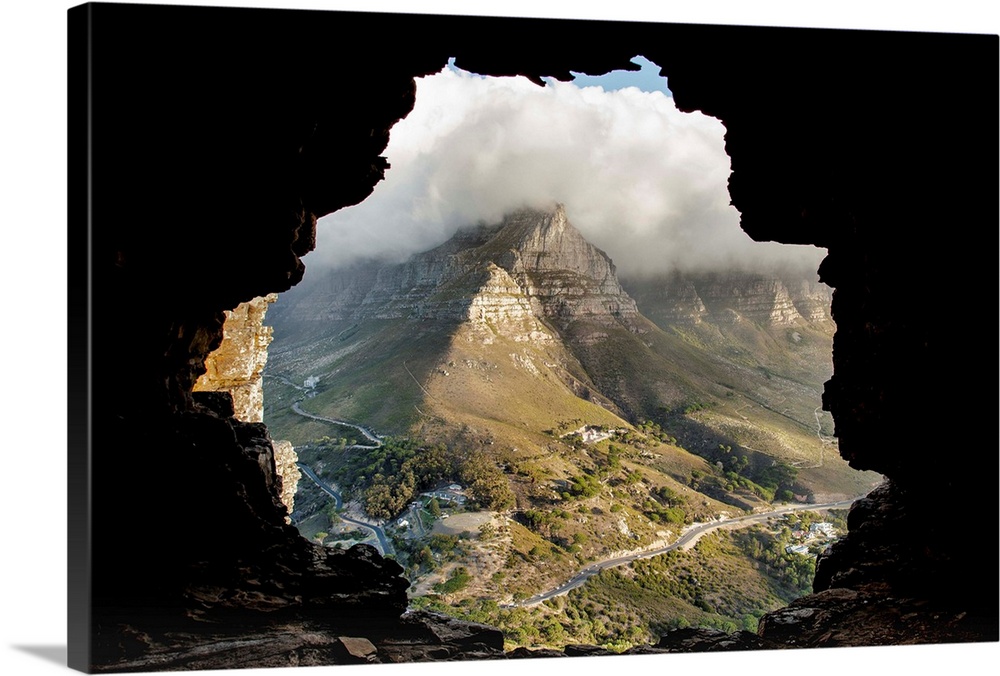 A key hole view of a mountain from the inside of a cave.
