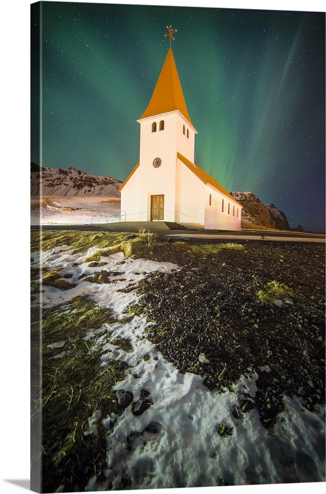 Northern lights in the sky over a church in Vik i Myrdal, Iceland, at night.