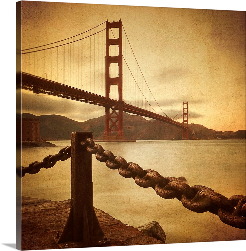 This large square print is a low angle view of the Golden Gate Bridge from land where there is a large chain shown in fron...