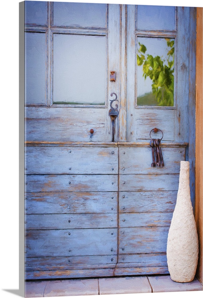 A photograph of a tall vase sitting in front of a blue cottage door.