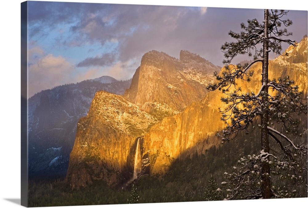 Large canvas photo print of big rugged mountains with a waterfall highlighted with the warm colors of a setting sun.