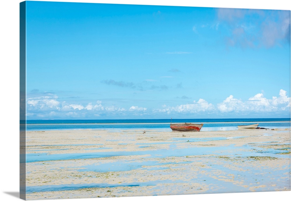 Photograph of a calm sea with a row boat along the shoreline.