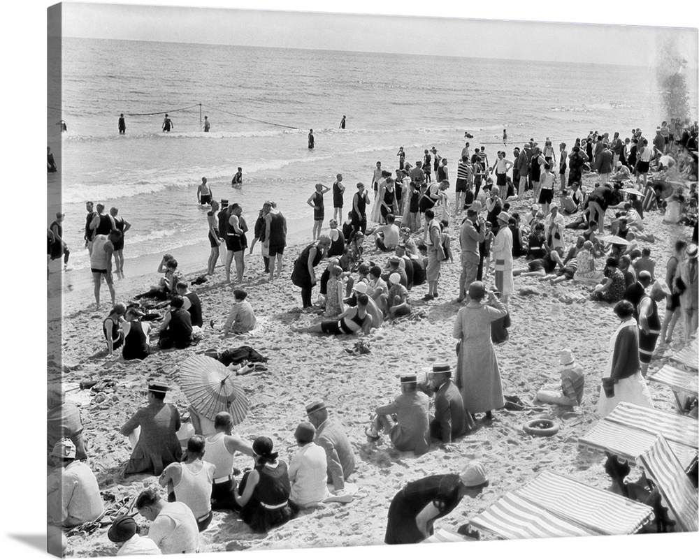 1920s Crowd Of People Some Fully Clothed Others In Bathing Suits On Palm Beach In Florida USA.