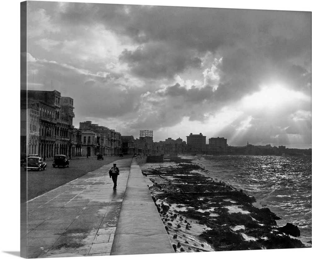 1930's 1940's Anonymous Silhouetted Man Walking Along Havana Sea Wall At Sunset Cuba.