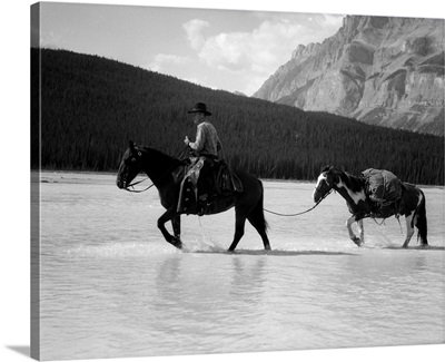 1930s 1940s Cowboy On Horseback Crossing River With 2nd Horse In Tow