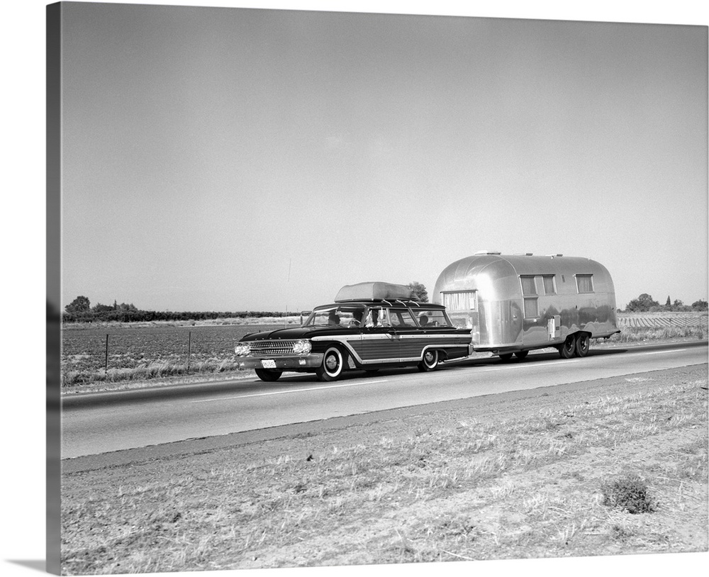 1960's 1970's Family Station Wagon And Camping Trailer Driving On Country Highway On Vacation.