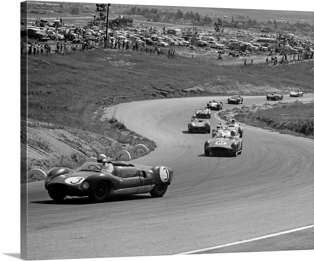 1960's Auto Race On Serpentine Section Of Track With Spectators Watching From Small Hill.