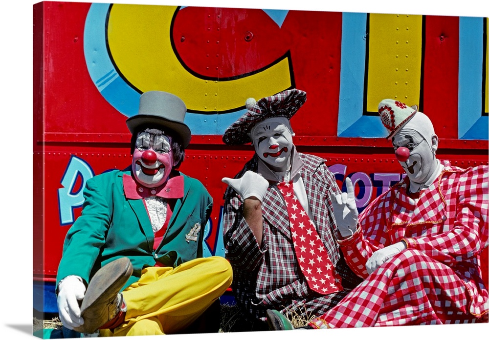 1970s Three Circus Clowns In Colorful Costumes And Hats Looking At Camera Two Picking On One.