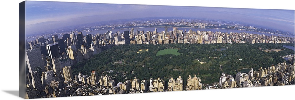 Wide angle, aerial photograph of Central Park beneath a blue sky, surrounded by the skyscrapers of New York City.