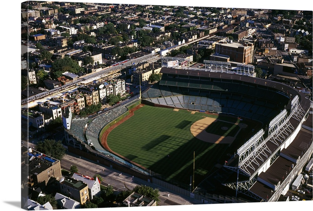 Big, horizontal, aerial photograph of Wrigley Field in the sunlight, surrounded by the city, in Chicago, Cook County, Illi...