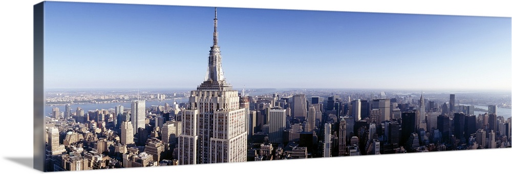 A high angle photograph of the NYC skyline with the Empire State building in the foreground towering over the skyscrapers.