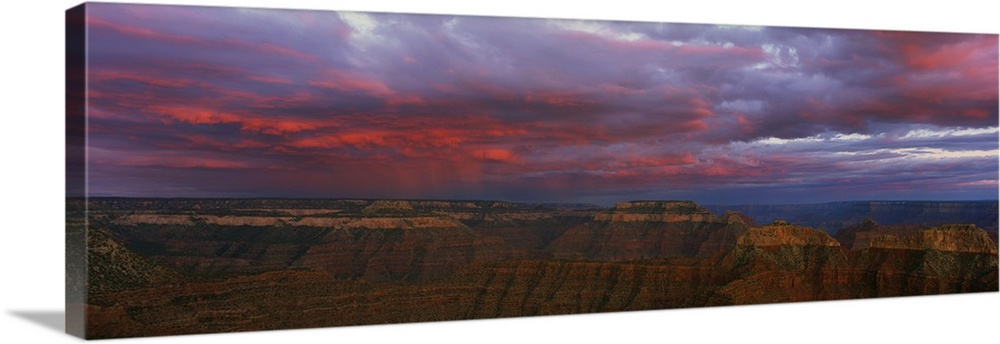 Panoramic photo taken on the rim of the Grand Canyon looking out towards the other side as clouds roll in at sunset creati...