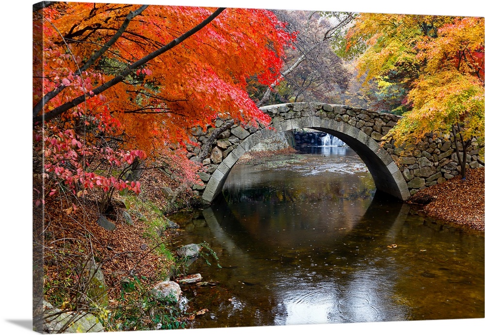 Autumn color and old stone arched bridge at namsangol traditional folk village, seoul, South Korea.