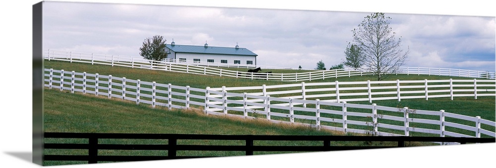 Horse corral fences and barn in Kentucky.	In Lebanon, KY a hillside of white and black fences of horse corrals and horse b...
