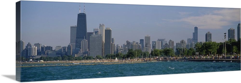 Oversized, landscape photograph of the Chicago skyline, a crowded beach at the waters edge in the foreground.