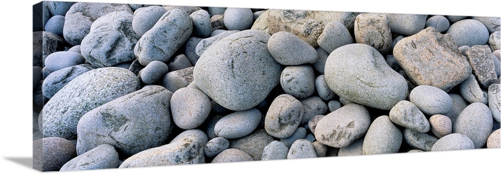 Up-close panoramic photograph of seaside pebbles and rocks.