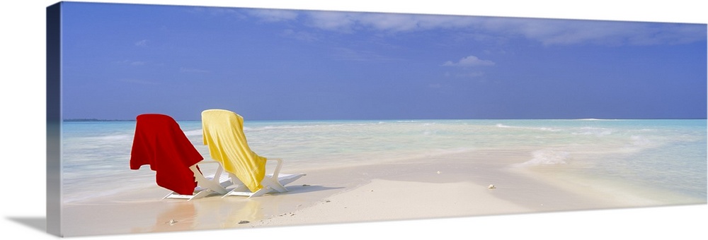 An image of two beach chairs sitting on a sandbar with clear ocean water washing up on shore nearby on canvas.