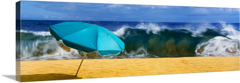 Beach umbrella with waves in the background, halawa beach park, halawa bay, island of molikai, hawaii, USA.