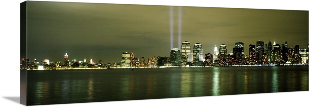 Panoramic cityscape on canvas of NYC lit up with two beacons of light shooting upwards in place of the World Trade Center ...