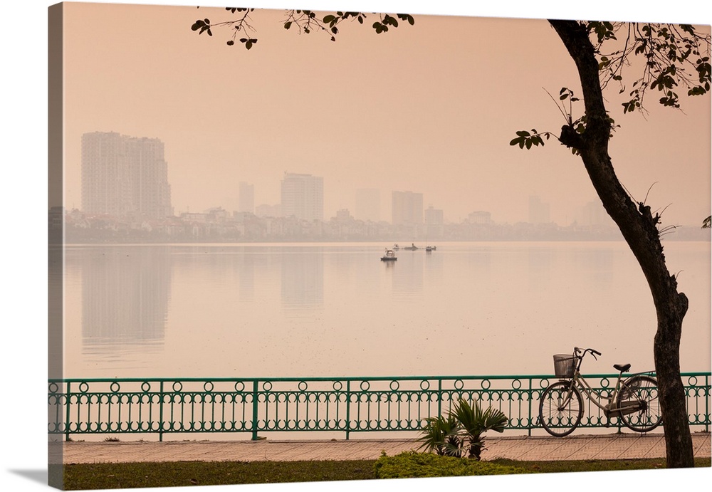 Bicycle parked at the lakeside with city skyline in the background, west lake, tay ho, hanoi, vietnam.