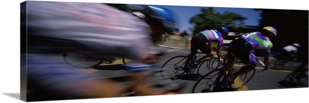 Panoramic blur motion photograph of cyclists racing on the street.