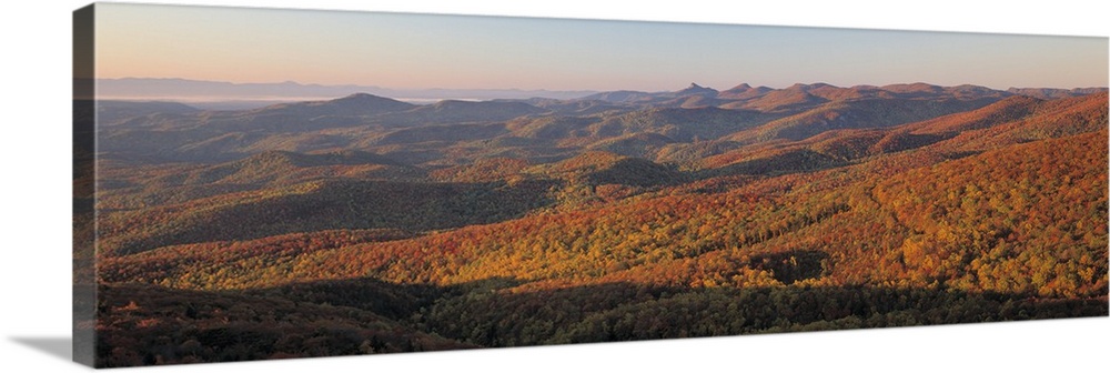Panorama of sunlight falling on the rolling hills along the Blue Ridge Parkway in North Carolina.