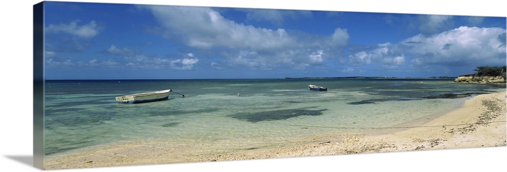 Long horizontal image on canvas of boats floating in the ocean near a shore.
