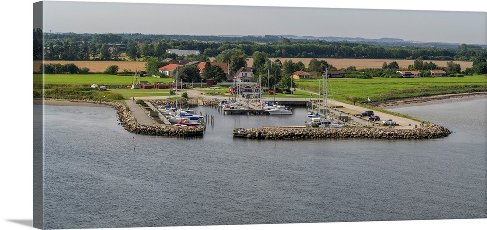 Boats moored at harbor with village in the background, Limfjord, Jutland, Denmark