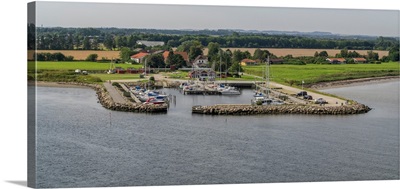 Boats moored at harbor with village in the background, Limfjord, Jutland, Denmark