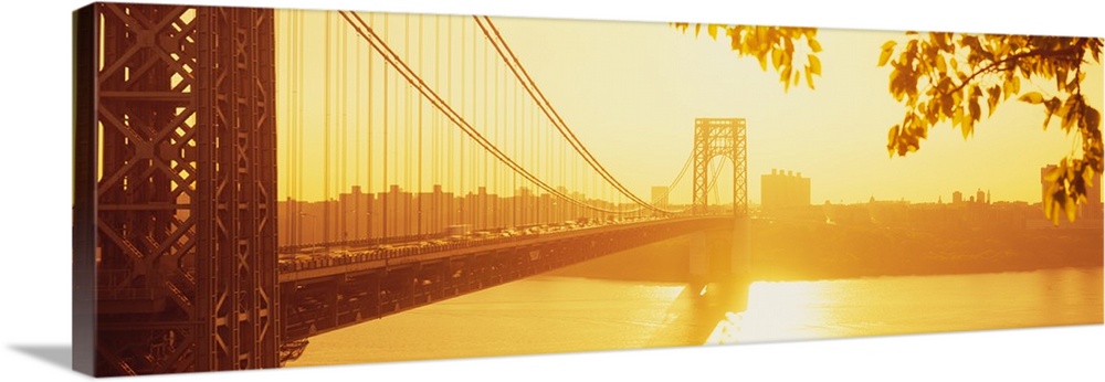 Panorama photograph taken of the George Washington bridge during sun down which gives the picture a golden hue.