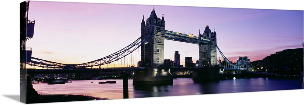 Panorama of the Tower Bridge at dusk with color reflections in the Thames River of London, England.