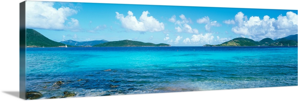 This wall art for the home or office is a panoramic photograph of a tropical beach surrounded by small islands.