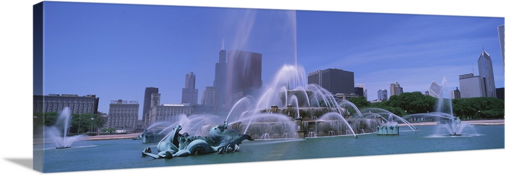 Landscape, close up photograph of Buckingham Fountain during the day, the skyscrapers of Chicago in the background, beneat...