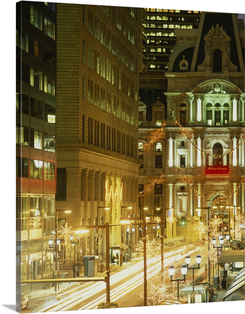 Vertical photograph on a big canvas of a brightly lit street in Philadelphia and city hall lit at night.