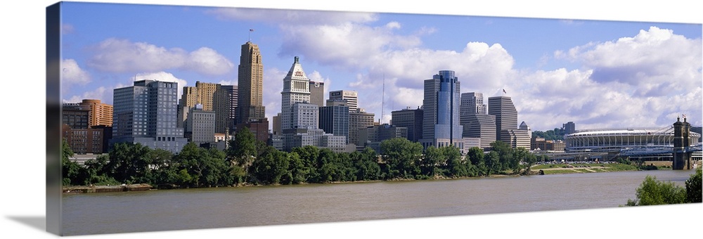 Wide angle picture taken of the Cincinnati skyline from across the river that it sits on.