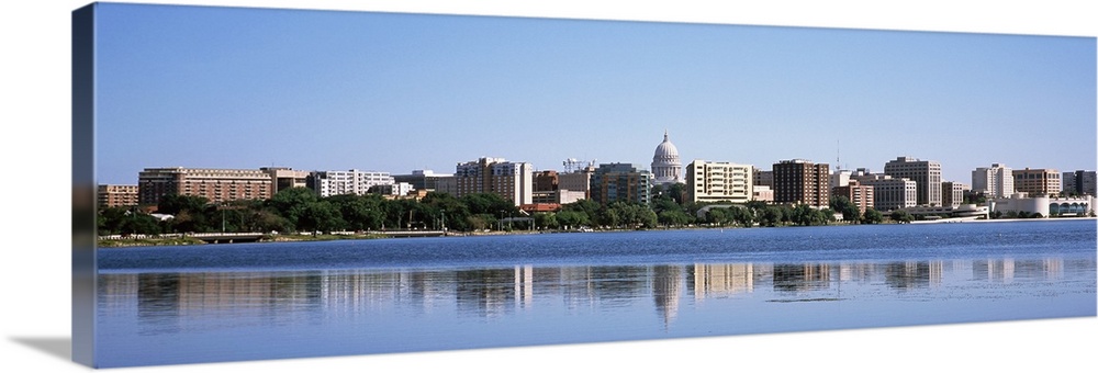 Panoramic picture taken of the city skyline in the capitol of Wisconsin. There is a body of water in front of the skyline ...