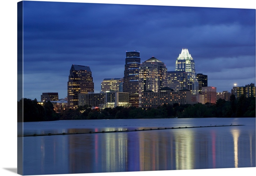 Buildings at the waterfront lit up at dusk, Town Lake, Austin, Texas