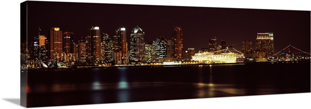 Panoramic photograph on a big wall hanging of the San Diego skyline along the edge of the water, lit up at night.