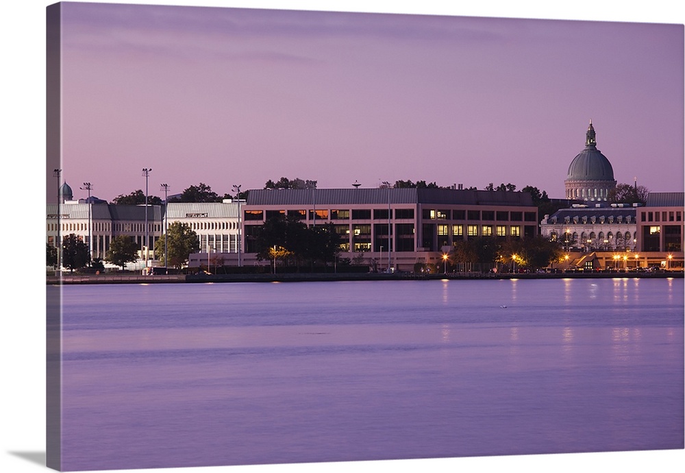 Wall art of the US Naval Academy building on the waterfront at dusk.