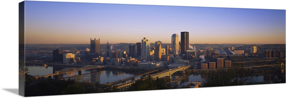 Panoramic photograph of skyline and water front at dusk.