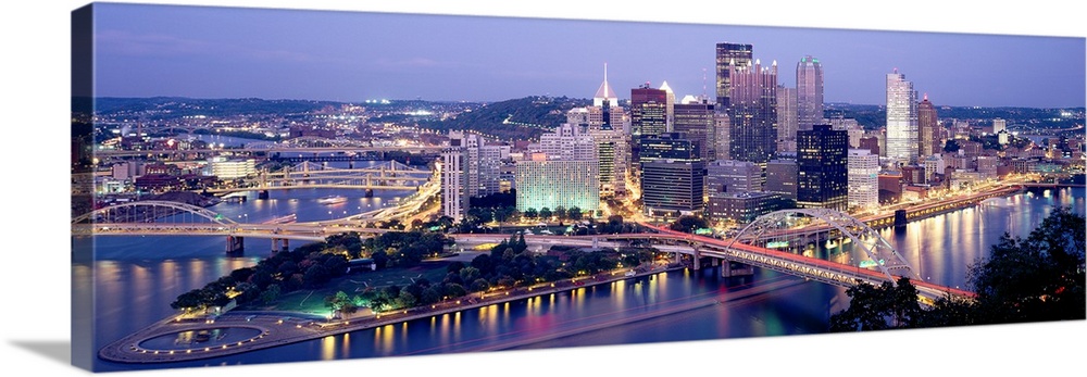 Panoramic canvas of a cityscape by a river with bridges spanning across it at dusk.