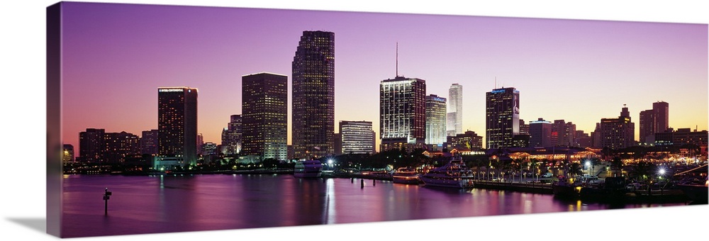 Panoramic photo of the city skyline lighting up as the sun sets  in Miami, Florida.