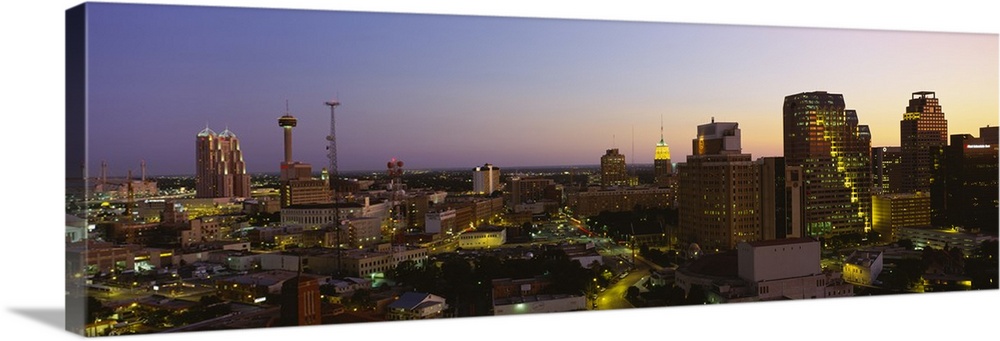 Big panoramic view of the San Antonio skyline lit up while the sun is setting.