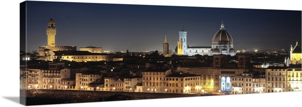 Long and horizontal photo on canvas of the cityscape of Tuscany illuminated at night.