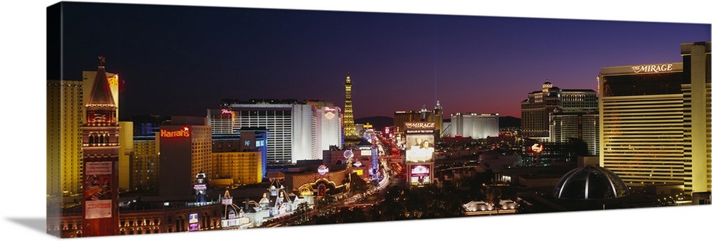 Panoramic photograph focuses on the busy strip surrounded by famous hotels and casinos like The Mirage and Harrah's.  In t...